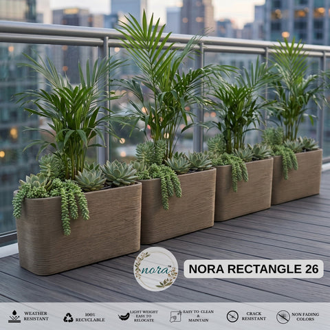 Nora 26-inch rectangular planters with textured stone finish and lush green plants on a modern balcony.
